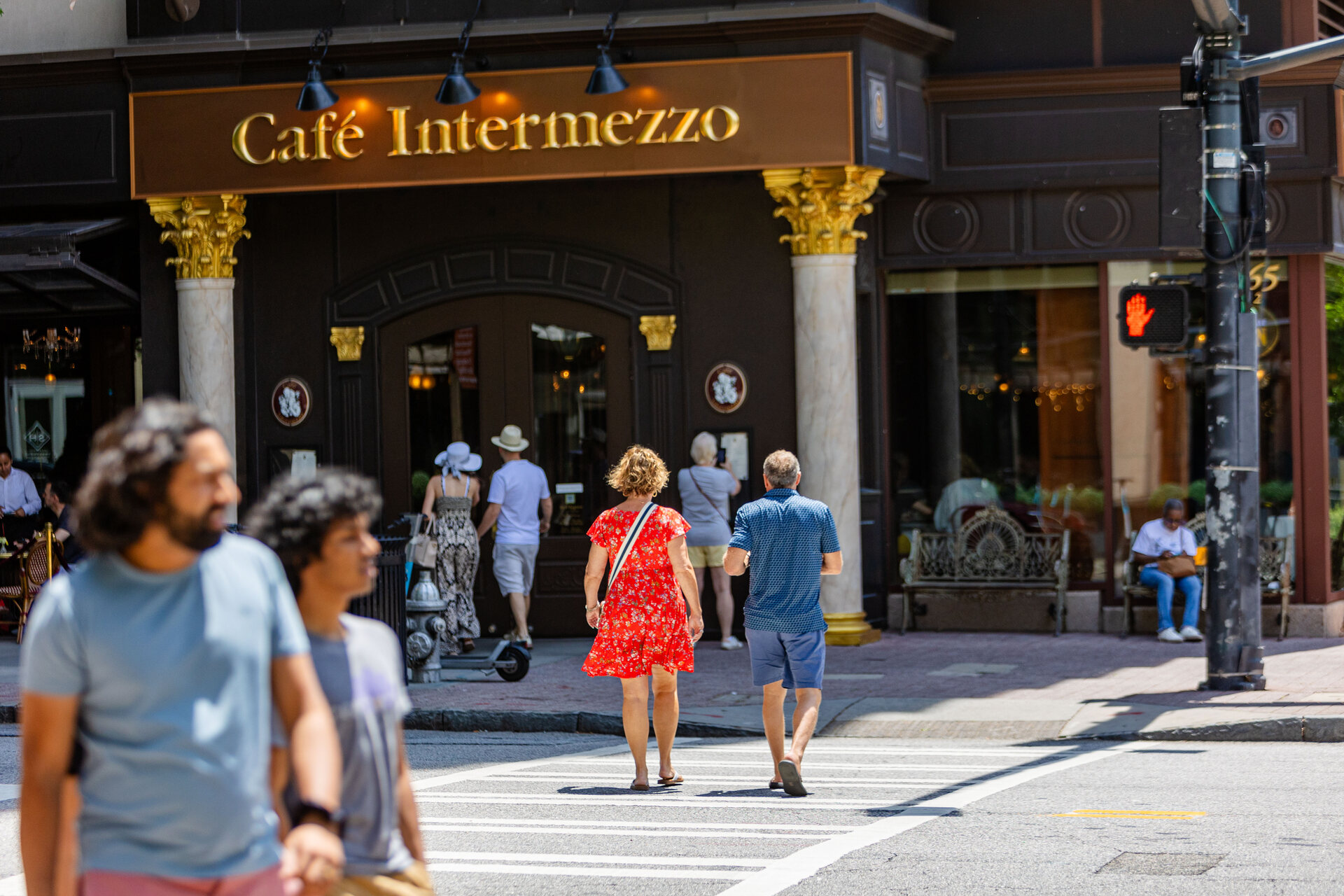 People walking in front of Cafe Intermezzo near Emmi Midtown