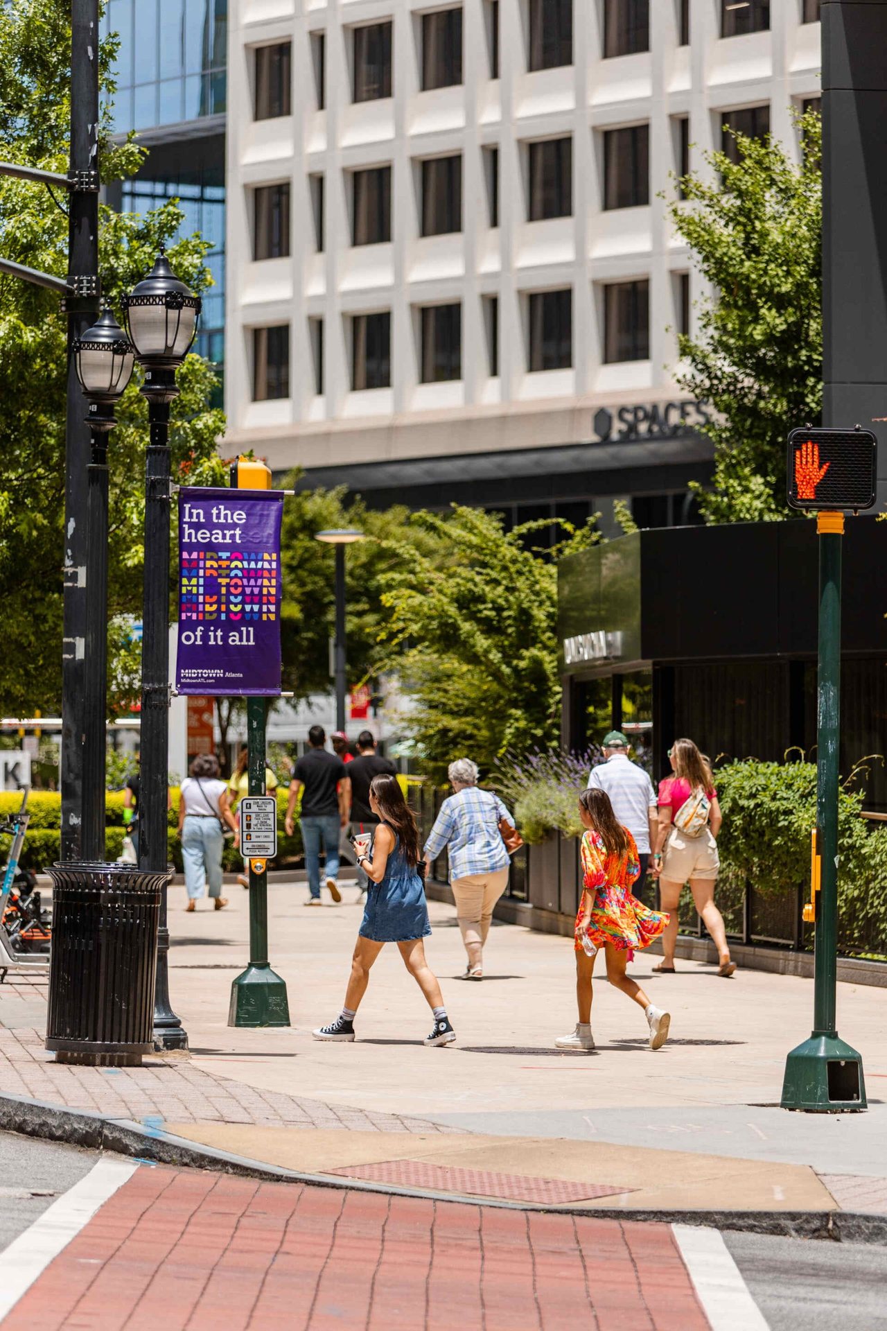 An intersection near Emmi Midtown featuring people walking